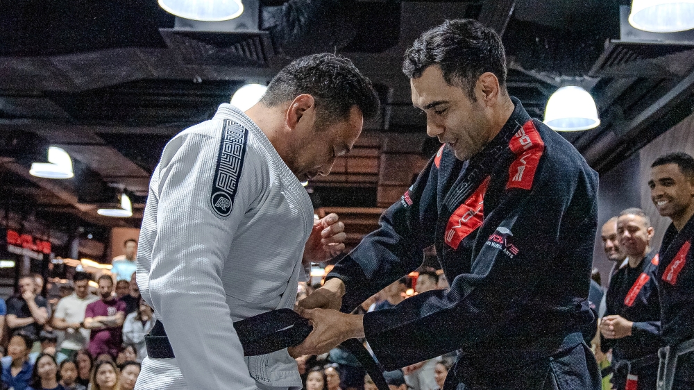 A BJJ student being promoted to black belt by BJJ Champion Thales Nakkasu.