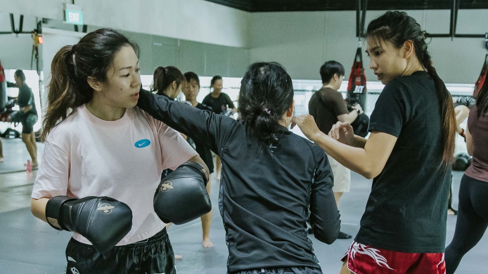 Muay Thai World Champion Saifa Suparut answering a student's question during a Muay Thai Class at Evolve Far East Square.